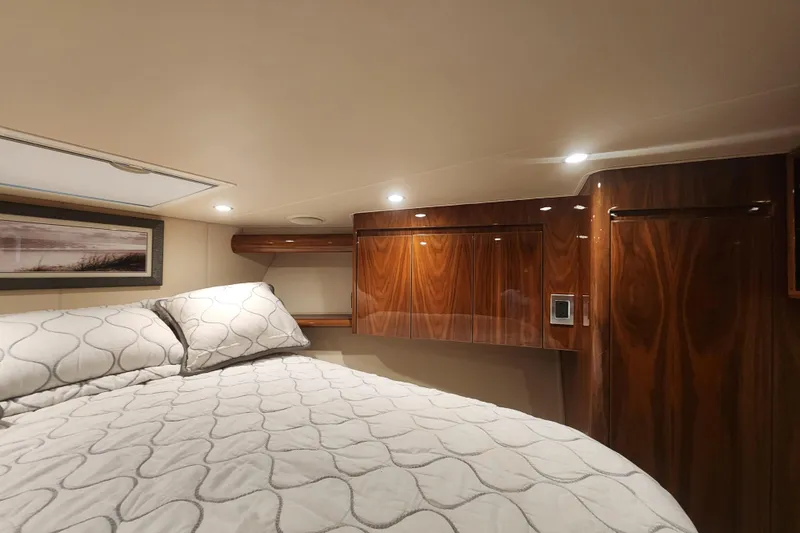 Slide: The Image of Luxurious cabin interior of 2018 Viking 48 Sport Tower with wood paneling and cozy bedding. - 68