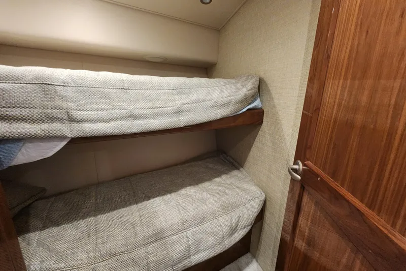 Slide: The Image of Bunk beds in 2018 Viking 48 Sport Tower cabin with wooden door. - 74