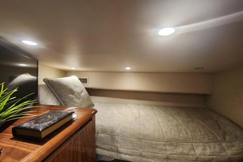 Slide: The Image of Cozy cabin interior of 2018 Viking 48 Sport Tower with bed and wooden nightstand. - 75