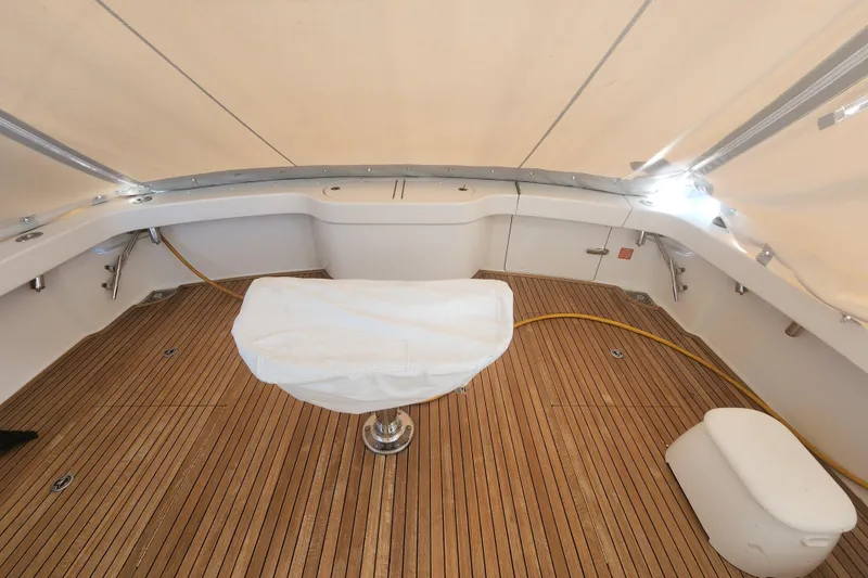 Slide: The Image of 2018 Viking 48 Sport Tower deck with teak flooring and covered seating area. - 78