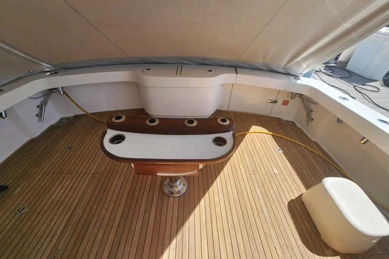 Slide: The Image of 2018 Viking 48 Sport Tower cockpit with teak flooring and fishing rod holders. - 83