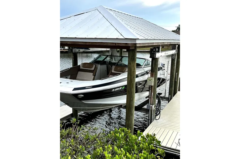 The Image of 2017 Crownline Eclipse E29 XS boat docked under a covered lift. - 0