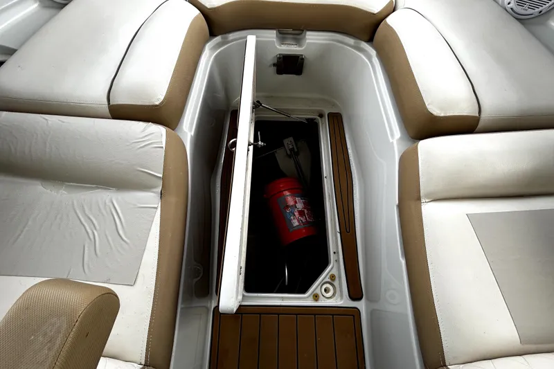 Slide: The Image of 2017 Crownline Eclipse E29 XS boat interior with open storage compartment and fire extinguisher. - 13