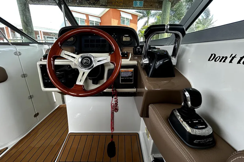 Slide: The Image of 2017 Crownline Eclipse E29 XS boat cockpit with wooden steering wheel and control panel. - 28