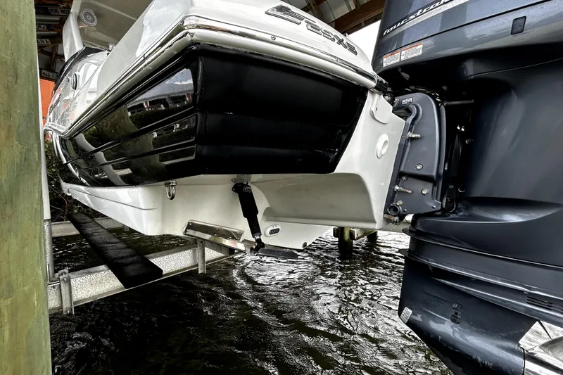 Slide: The Image of 2017 Crownline Eclipse E29 XS boat on lift, showcasing hull and outboard motor. - 3