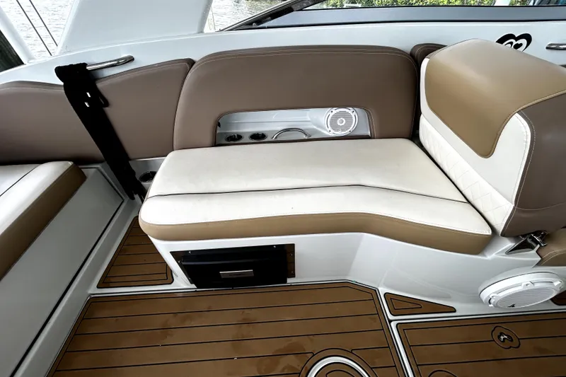 Slide: The Image of 2017 Crownline Eclipse E29 XS boat interior with tan and white seating and wood-style flooring. - 42