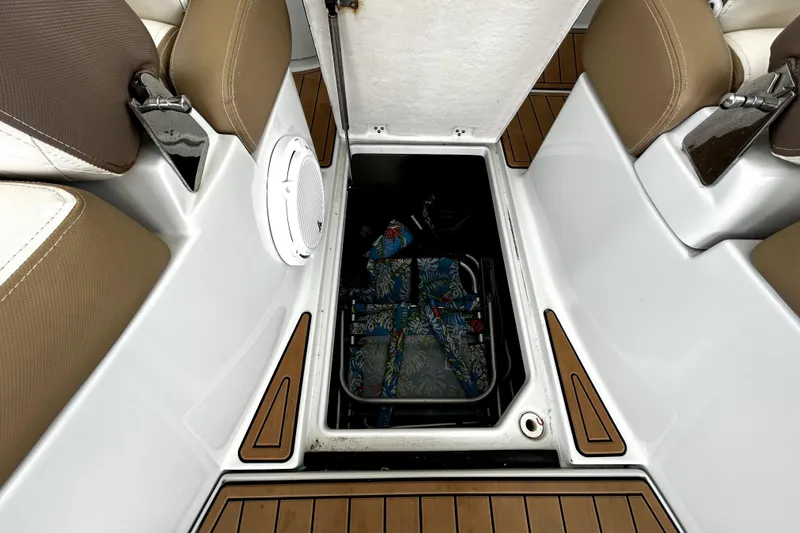 Slide: The Image of 2017 Crownline Eclipse E29 XS boat storage compartment with brown seating and teak flooring. - 46