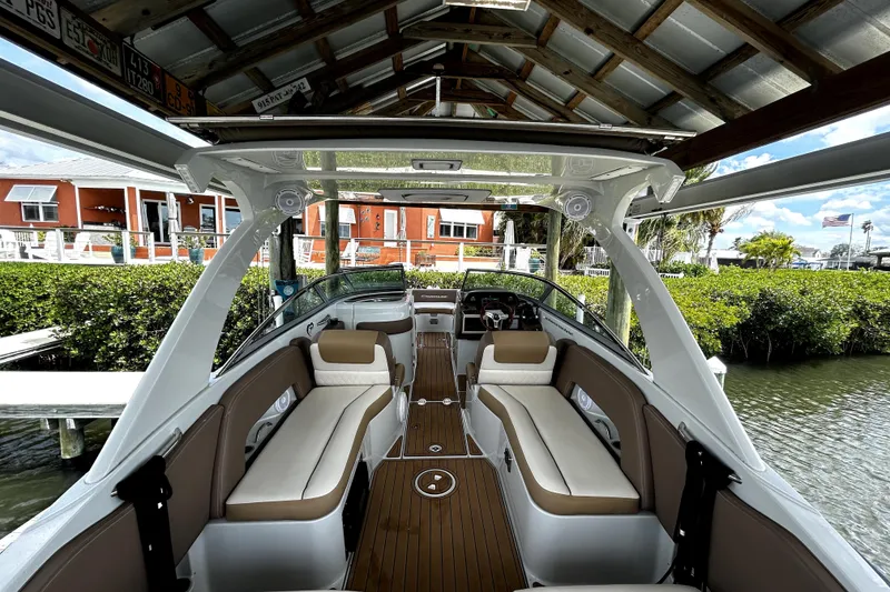 Slide: The Image of 2017 Crownline Eclipse E29 XS boat interior with beige seating and wooden flooring. - 5