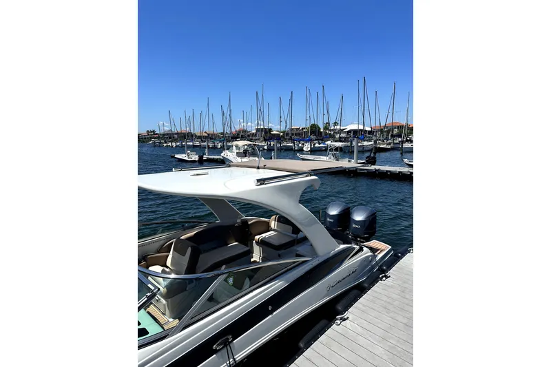 Slide: The Image of 2017 Crownline Eclipse E29 XS boat docked at marina with sailboats in background. - 67