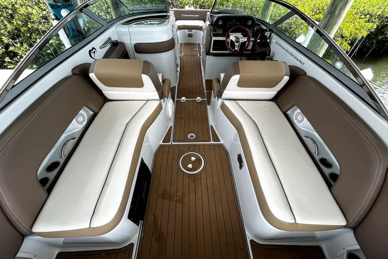 Slide: The Image of 2017 Crownline Eclipse E29 XS boat interior with brown and white seating, wood flooring. - 7