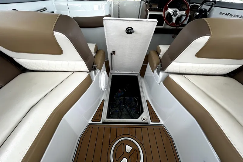 Slide: The Image of 2017 Crownline Eclipse E29 XS interior with open storage compartment, brown and white seating. - 8