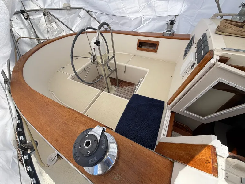 Slide: The Image of Cockpit of a 1985 Benford 39 sailboat, featuring steering wheel and wood trim. - 4