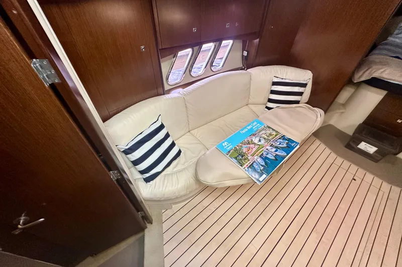 Slide: The Image of Interior of 2011 Cruisers Yachts 420 Sports Coupe with cream sofa and striped pillows. - 15
