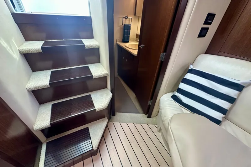 Slide: The Image of Interior of 2011 Cruisers Yachts 420 Sports Coupe, featuring stairs, seating, and bathroom entrance. - 21