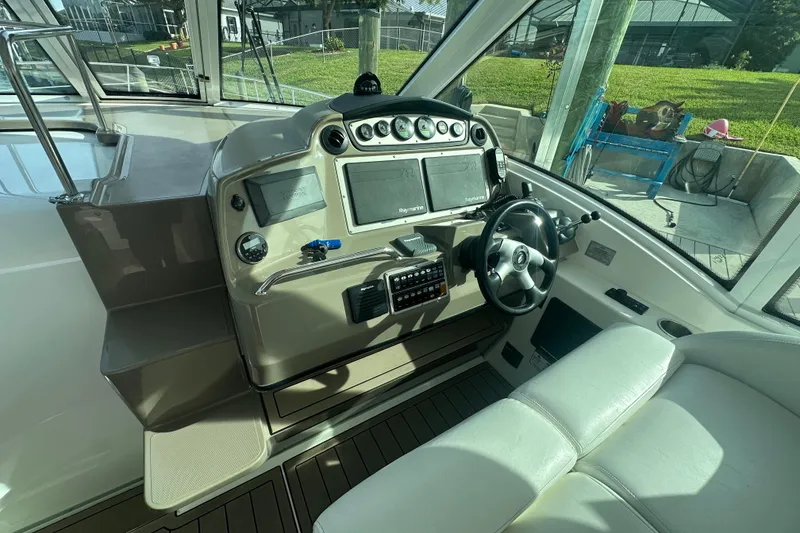 Slide: The Image of 2011 Cruisers Yachts 420 Sports Coupe helm with modern navigation equipment and comfortable seating. - 9