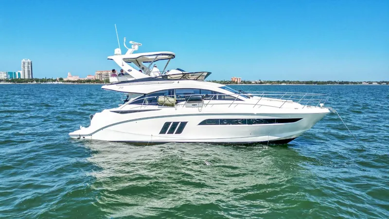 Slide: The Image of 2015 Sea Ray 510 Fly yacht cruising on open water under clear blue sky. - 4