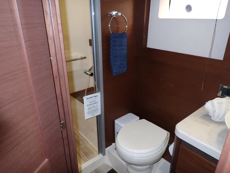Slide: The Image of 2015 Sea Ray 510 Fly bathroom with shower, toilet, and sink in wooden interior. - 48
