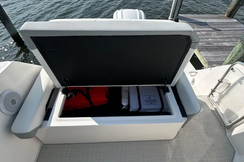 Slide: The Image of 2024 Regal 26 XO boat storage compartment with safety equipment and life jackets. - 17