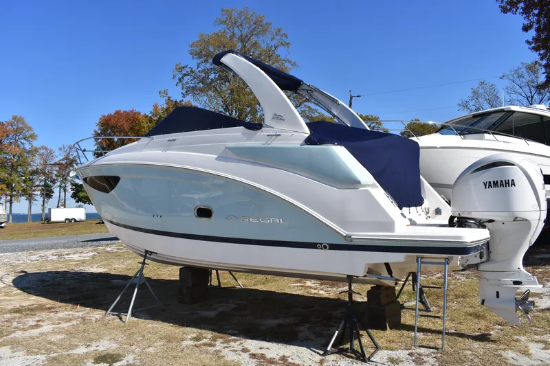 Slide: The Image of 2024 Regal 26 XO boat with Yamaha engine on display outdoors. - 2