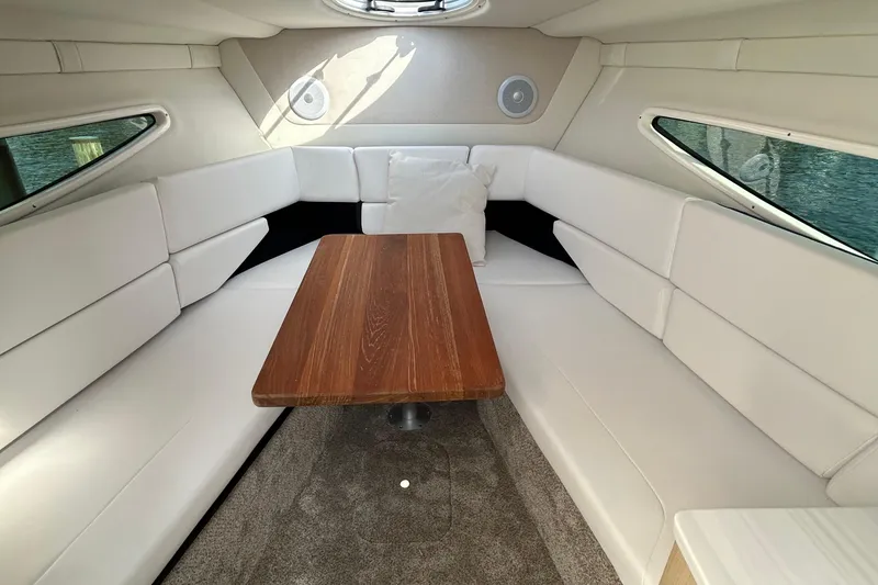 Slide: The Image of 2024 Regal 26 XO cabin interior with white seating and wooden table. - 20