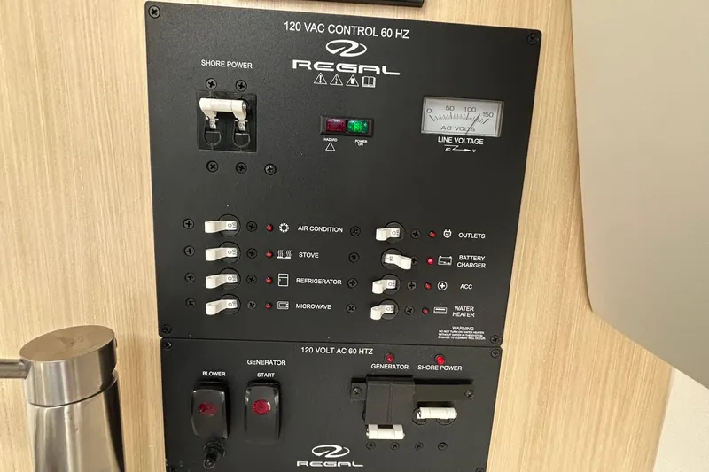 Slide: The Image of 2024 Regal 26 XO control panel with switches for air conditioning, stove, and more. - 23