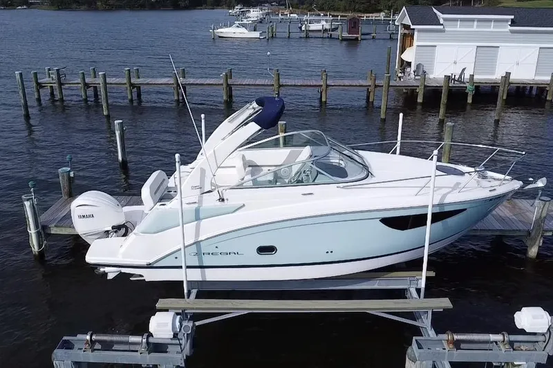 Slide: The Image of 2024 Regal 26 XO boat docked on a lift, featuring sleek design and Yamaha outboard motor. - 5