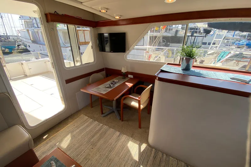 Slide: The Image of Interior of 2003 Zeta 36 yacht with dining area, TV, and marina view. - 10