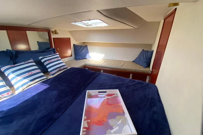 Slide: The Image of Cozy cabin interior of 2003 Zeta 36 boat with blue bedding and striped pillows. - 19