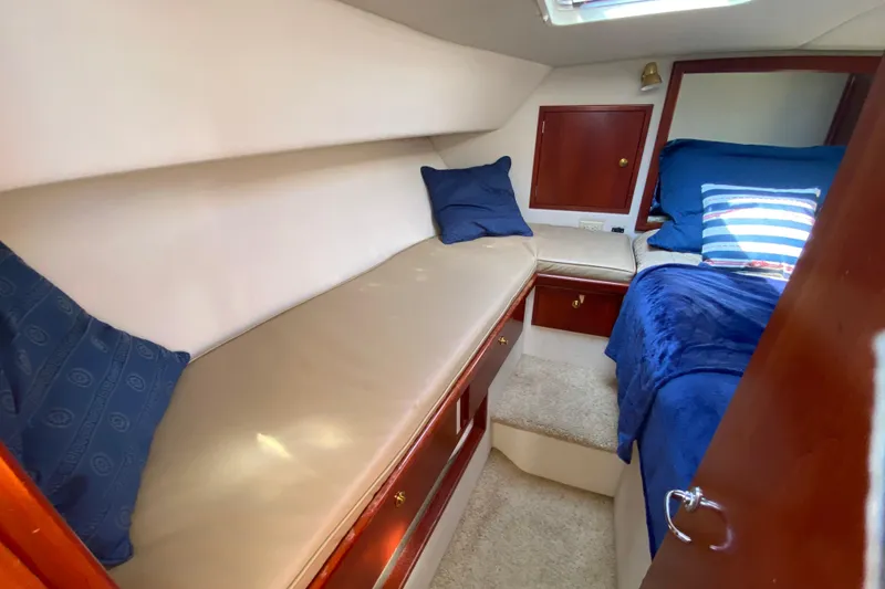 Slide: The Image of 2003 Zeta 36 yacht cabin with cozy seating, blue pillows, and wooden accents. - 23