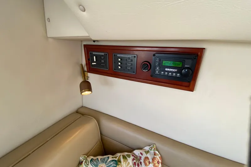 Slide: The Image of Control panel in a 2003 Zeta 36 boat interior with beige seating and floral pillow. - 43