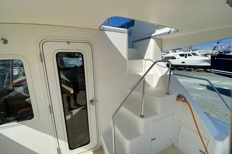 Slide: The Image of Staircase and door on 2003 Zeta 36 boat, docked with other vessels in background. - 46