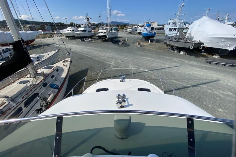 Slide: The Image of Boat yard with various vessels, including a 2003 Zeta 36, under clear blue skies. - 55