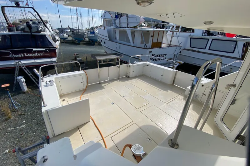 Slide: The Image of Open deck of a 2003 Zeta 36 boat, surrounded by other docked vessels. - 58