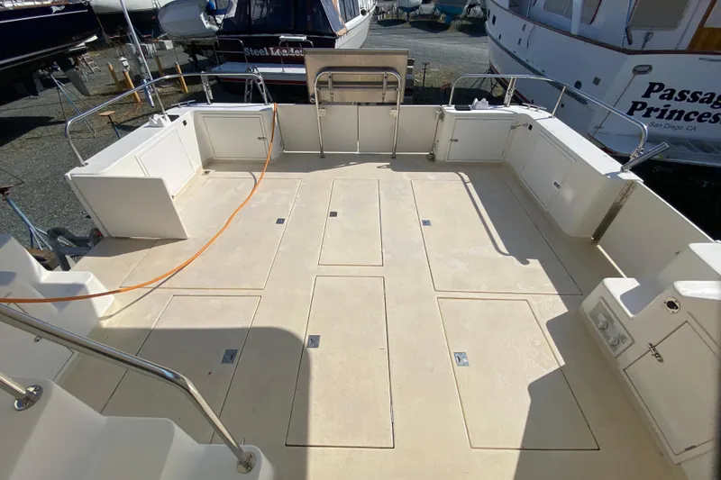 Slide: The Image of Spacious deck of 2003 Zeta 36 boat, featuring storage compartments and railing. - 59