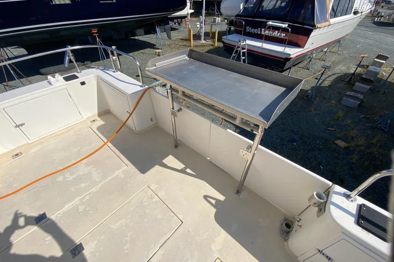 Slide: The Image of Boat deck of 2003 Zeta 36 with stainless steel table and storage compartments. - 60