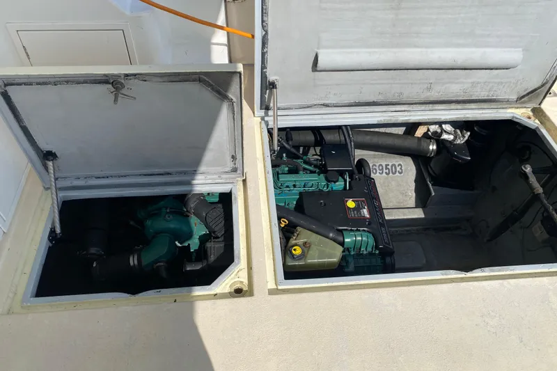 Slide: The Image of Open engine compartments of a 2003 Zeta 36 boat, showcasing mechanical components. - 64