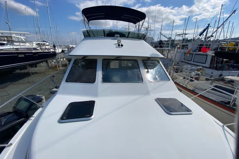 Slide: The Image of 2003 Zeta 36 boat docked among other vessels under a partly cloudy sky. - 68