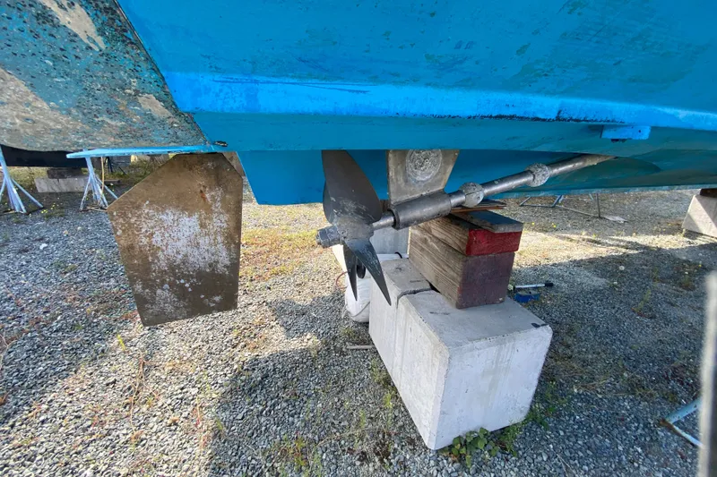 Slide: The Image of 2003 Zeta 36 boat propeller and rudder on dry dock, supported by blocks. - 77