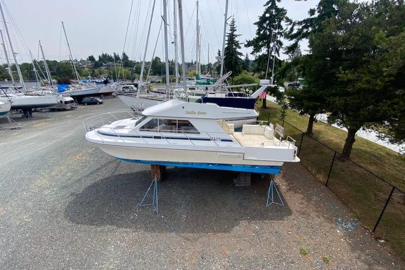 Slide: The Image of 2003 Zeta 36 boat on stands in a marina, surrounded by trees and other boats. - 81