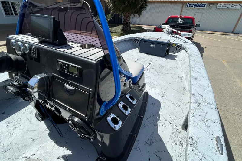 Slide: The Image of 2015 Haynie Magnum boat with advanced dashboard and equipment, parked near a red truck. - 10