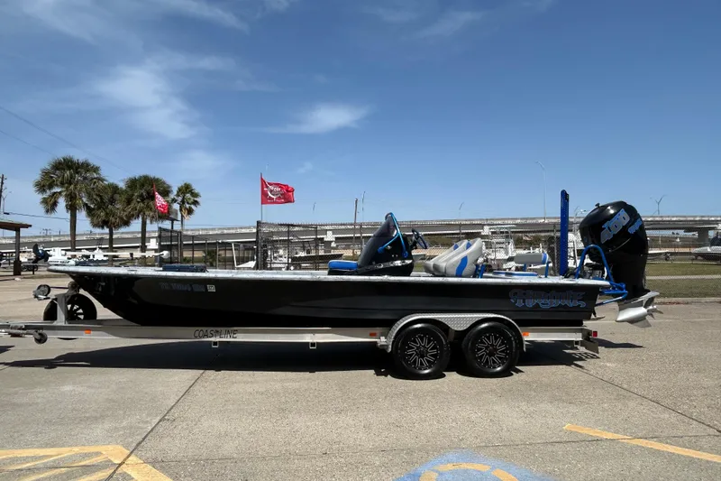 Slide: The Image of 2015 Haynie Magnum boat on trailer, parked outdoors under clear blue sky. - 12