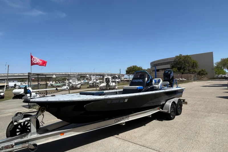 Slide: The Image of 2015 Haynie Magnum boat on trailer, parked outdoors under clear blue sky. - 13