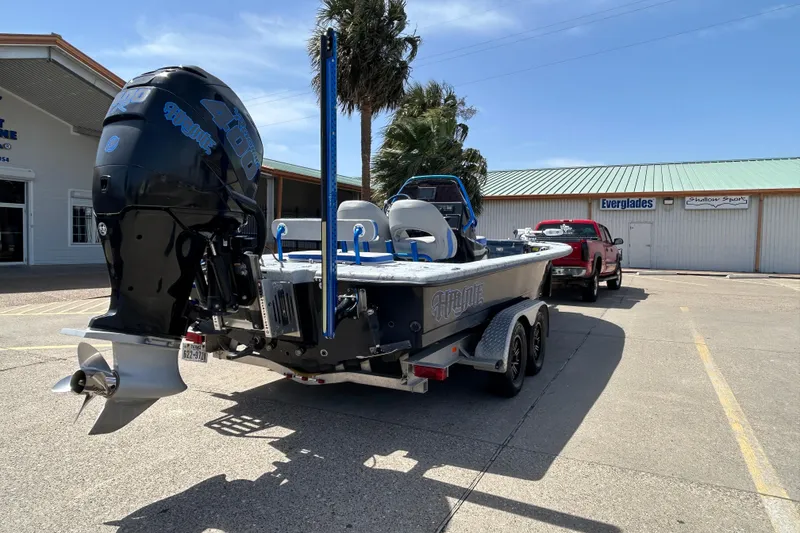 Slide: The Image of 2015 Haynie Magnum boat on trailer, parked outside a marine store under a clear blue sky. - 16