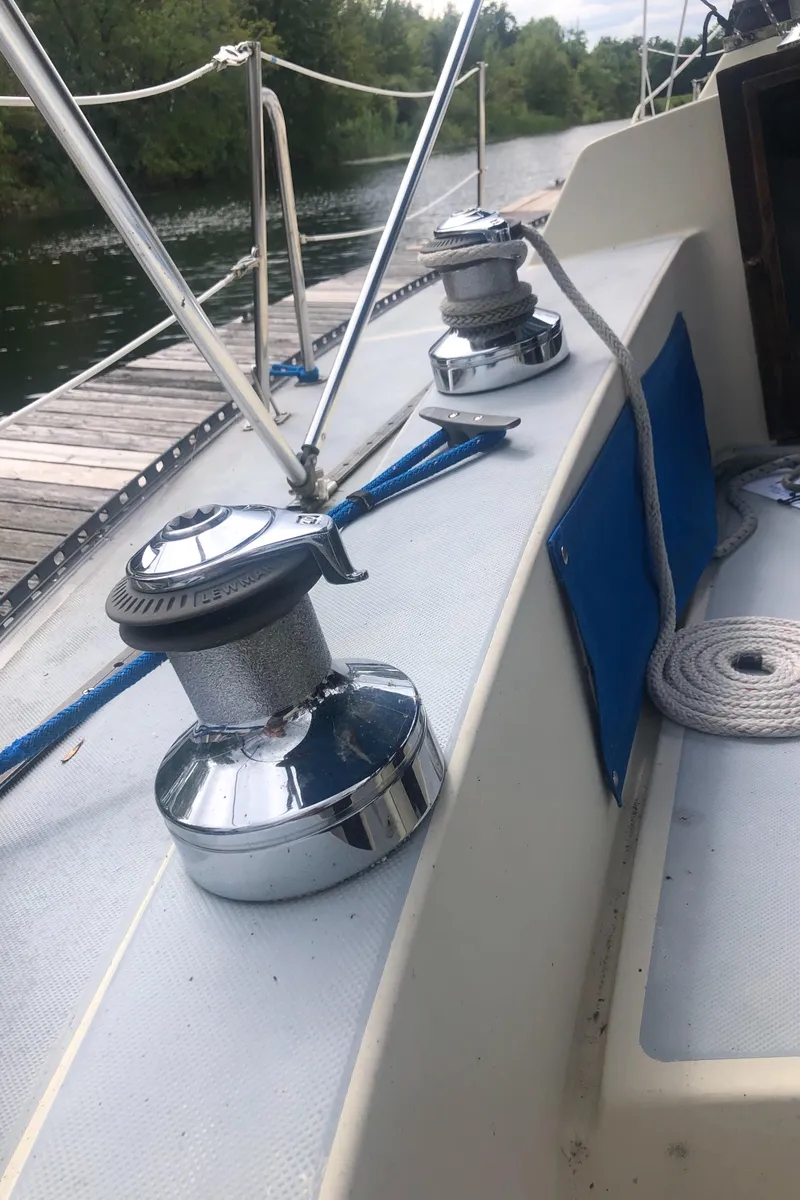 Slide: The Image of 1980 Lancer 36 sailboat deck with winches and ropes by a dock. - 12