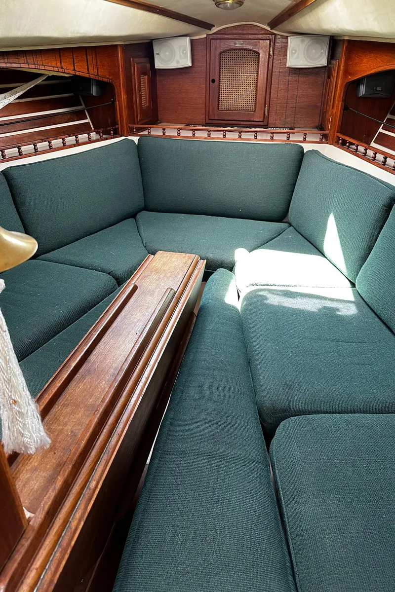 Slide: The Image of 1980 Lancer 36 yacht interior with green cushioned seating and wooden accents. - 22