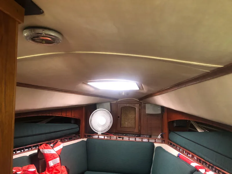 Slide: The Image of Interior of a 1980 Lancer 36 sailboat cabin with seating and a fan. - 23