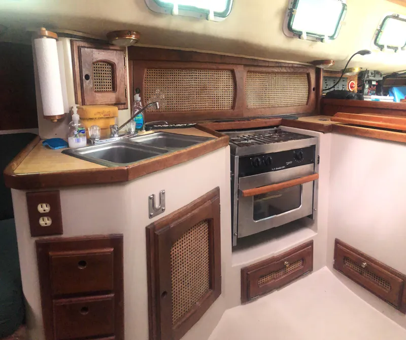 Slide: The Image of 1980 Lancer 36 yacht kitchen with wood cabinetry, sink, and stove. - 26