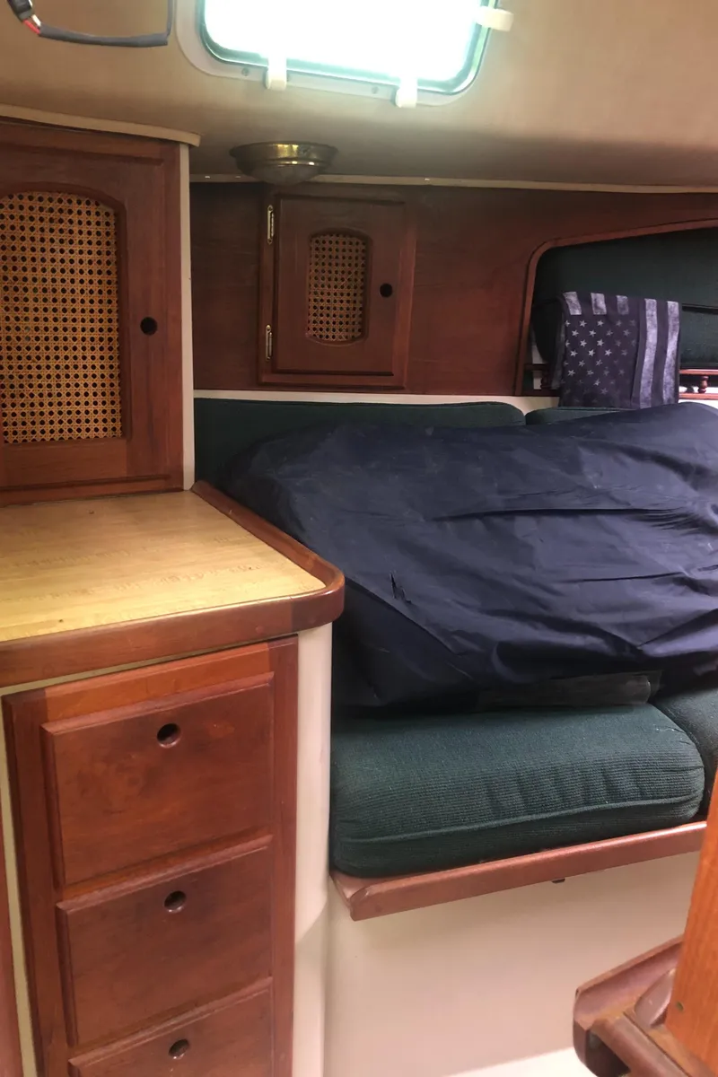 Slide: The Image of 1980 Lancer 36 yacht interior with wooden cabinets and cushioned seating. - 28