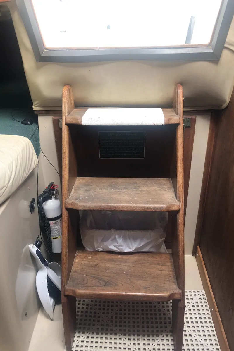 Slide: The Image of Wooden steps inside a 1980 Lancer 36 boat cabin, with a fire extinguisher nearby. - 47