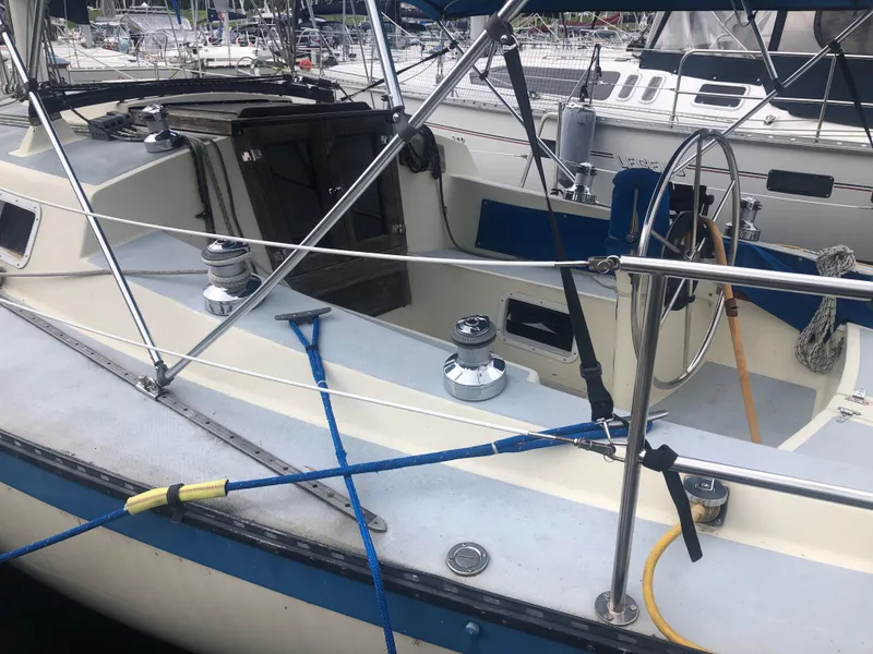 Slide: The Image of 1980 Lancer 36 sailboat cockpit with steering wheel and winches, docked at marina. - 8